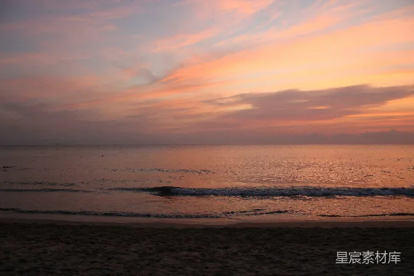 高清摄影 夕阳西下，海浪轻柔地拍打着沙滩。