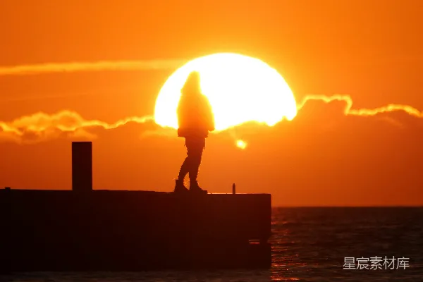 高清摄影 夕阳西下，人影在水面上的剪影。