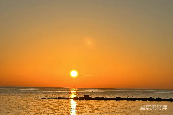 高清摄影 夕阳正挂在水边的海滩上。