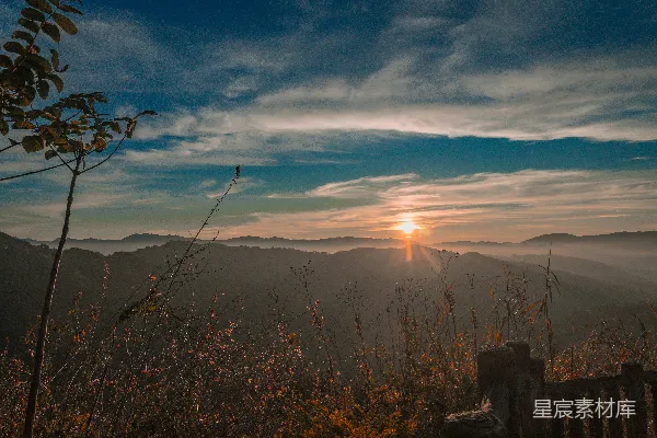 高清摄影 雾蒙蒙的山峦上空升起朝霞，天空中有戏剧性的云彩。
