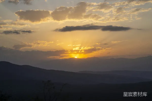 高清摄影 夕阳落山，映衬着轮廓鲜明的山脉，天空中布满了壮观的云彩。