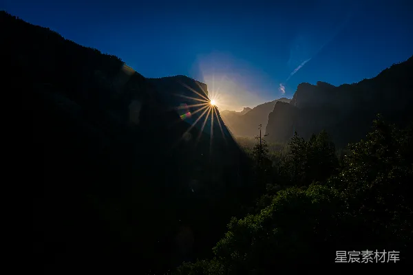 高清摄影 朝阳初升，阳光穿透乌云笼罩的山峰。
