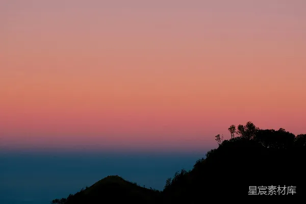 高清摄影 明月高挂于暗色的山峦之上，天空中有一片绚丽的夕阳。