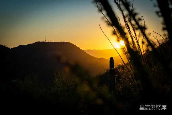 高清摄影 夕阳正缓缓落下，笼罩着连绵的山脉。