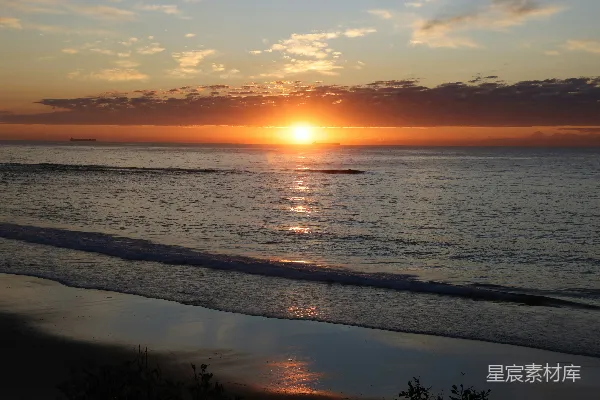 高清摄影 夕阳在海滩上空落下，照耀着海洋。