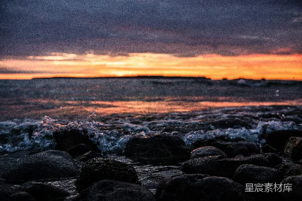 高清摄影 夕阳西下，海浪拍打着岩石海岸。