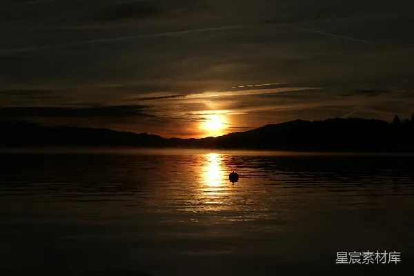 高清摄影 夕阳映照着一片宁静的湖面，湖中有一只浮标。