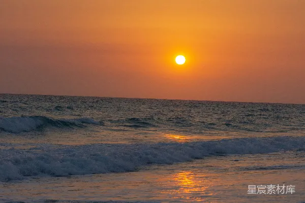 高清摄影 夕阳正缓缓落下，海面上的海滩一片宁静。