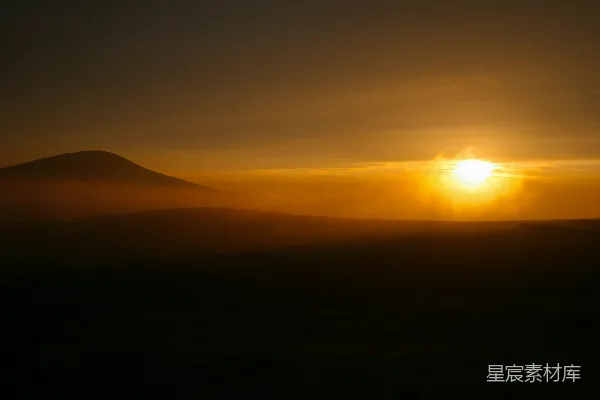 高清摄影 金色的夕阳在雾蒙蒙的山峰后缓缓落下。