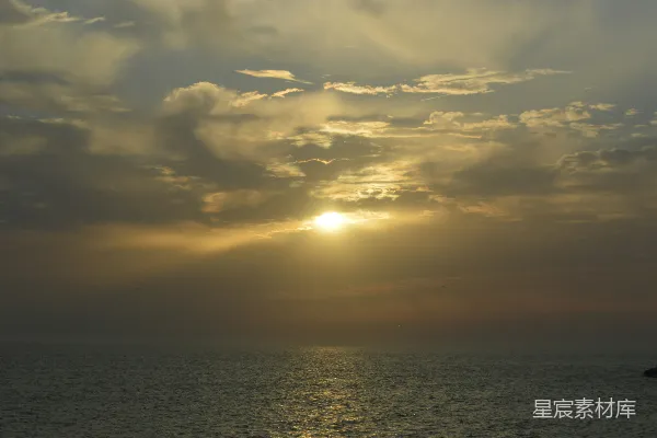 高清摄影 海上的日落，天空中有云。