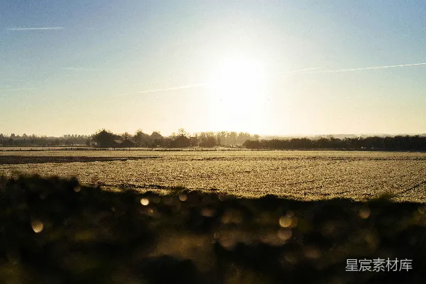 高清摄影 黎明时分，晴朗的太阳照耀着结霜的乡村景观。