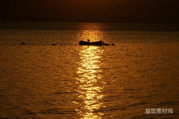 高清摄影 在夕阳下，一艘小船漂浮在海洋上。