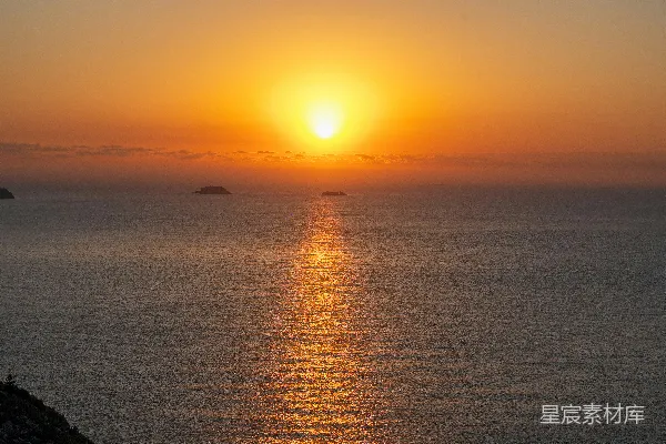 高清摄影 金色的太阳正缓缓落下，映照在平静的海洋上。