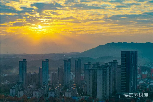 高清摄影 城市天际线上的日出，远处是连绵的山脉。