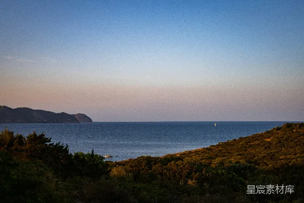 高清摄影 日落时分，海景如画，远处的帆船映衬在天边。