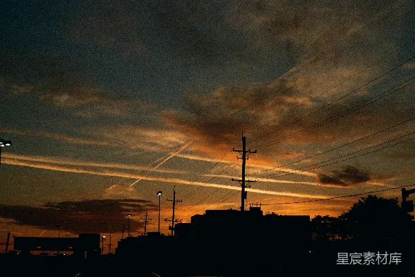 高清摄影 夕阳正照耀着一座城市，天空中有输电线路。