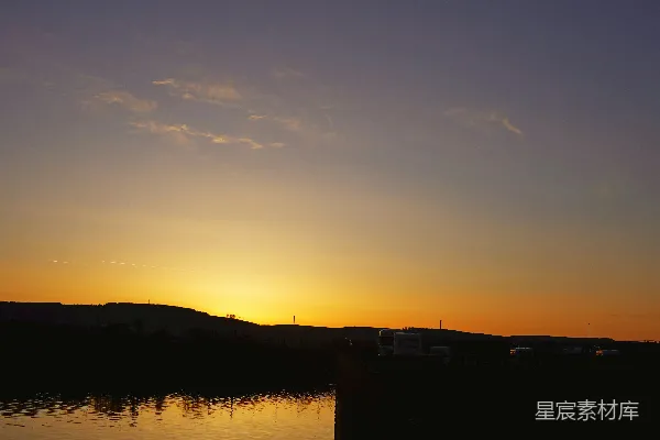 高清摄影 夕阳照耀着平静的湖面，路灯伫立其间。
