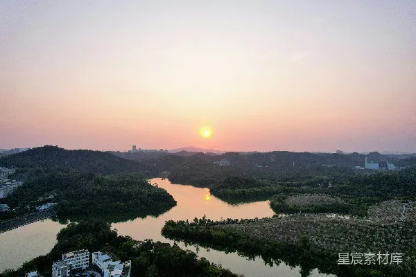 高清摄影 夕阳正挂在一条河流和一座城市的上方。