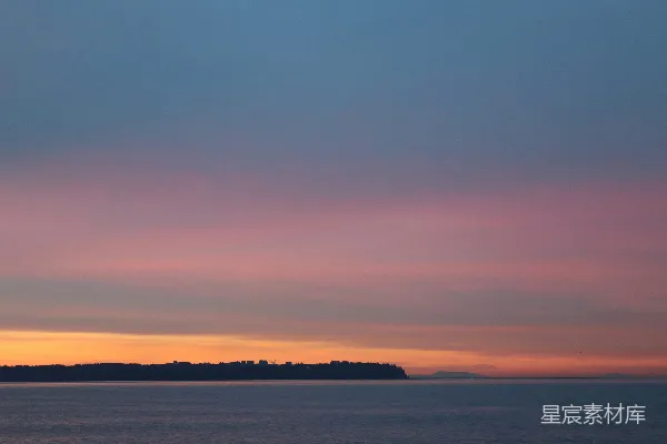 高清摄影 夕阳照耀着一片水域，远处有一个小岛。