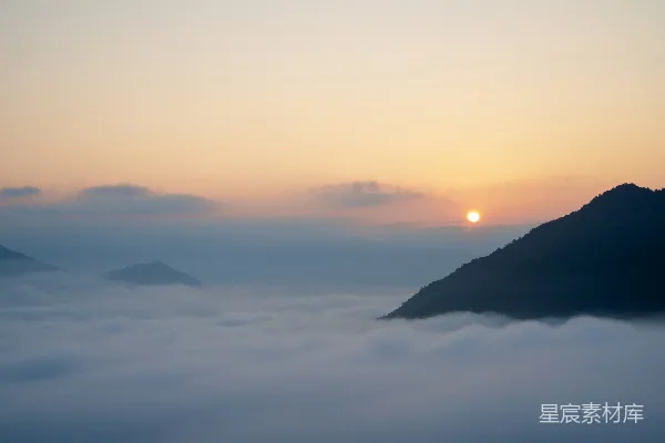 高清摄影 云海中旭日初升，山峰隐约可见。
