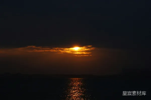 高清摄影 夕阳正缓缓落下，倒映在水面上。