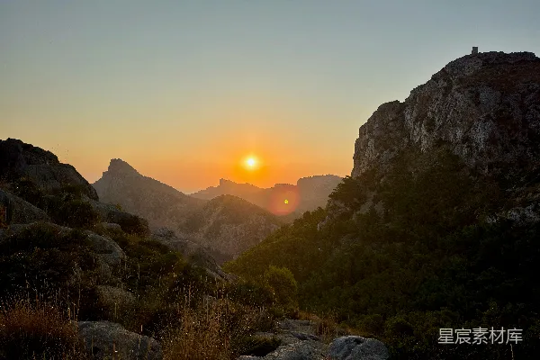 高清摄影 夕阳西下，映照在崎岖的山地景观上