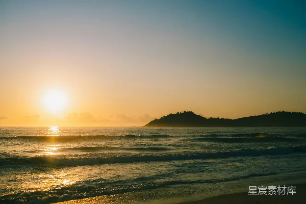 高清摄影 夕阳正缓缓落下，海面之上，远处有一座小岛。