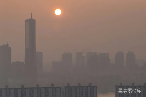 高清摄影 夕阳西下，笼罩着雾蒙蒙的城市景观，建筑群影影绰绰。