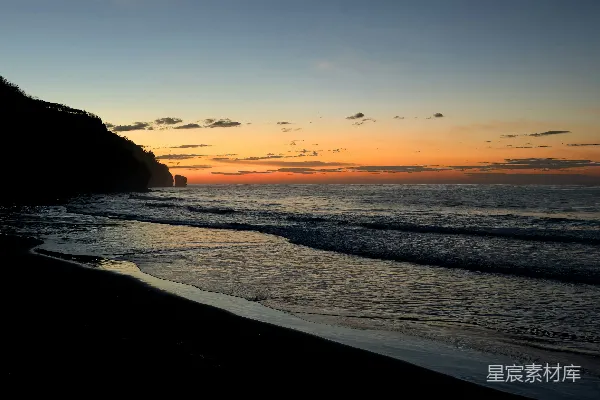 高清摄影 夕阳照耀着海滩，波浪翻滚。