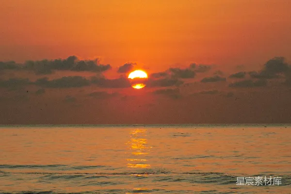 高清摄影 在多云的日子里，夕阳正从海平面上落下。