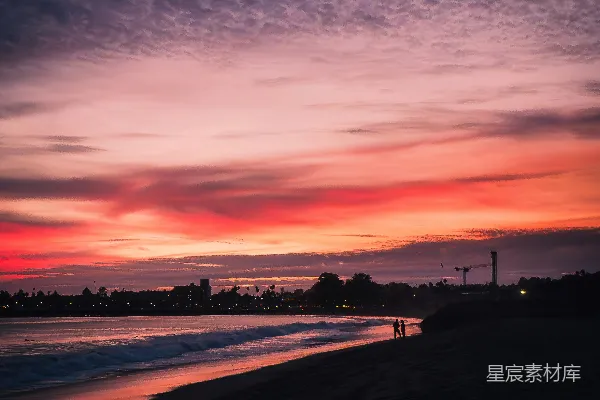 高清摄影 一个人站在海滩上，夕阳西下。