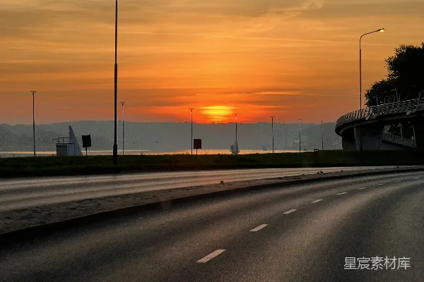 高清摄影 夕阳正挂在公路上方的天际。