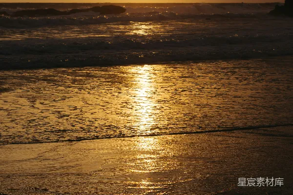 高清摄影 夕阳正缓缓落下，洒在海边的海面上。
