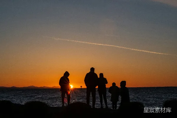 高清摄影 夕阳下，人们站在海边的剪影