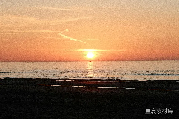 高清摄影 夕阳正缓缓落下，洒在海滩上。