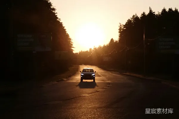 高清摄影 一辆车在夕阳下沿着街道行驶