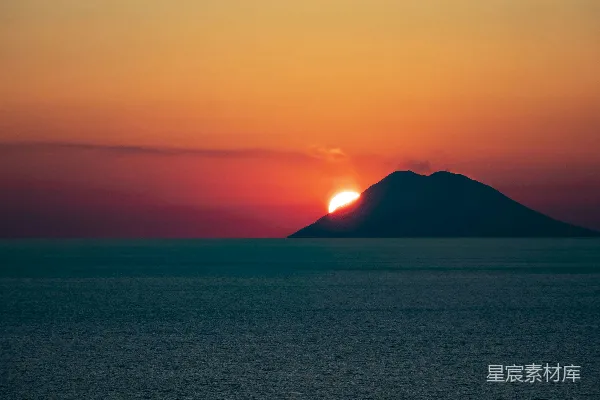 高清摄影 太阳正在海洋中一个小岛的上方落下。
