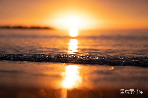 高清摄影 夕阳正映照在海滩上的水面。