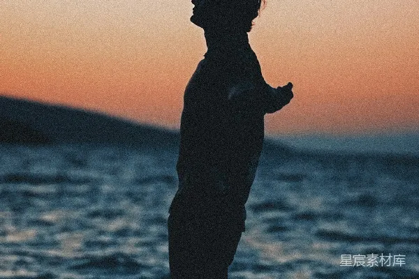 高清摄影 站在水边的人在日落时分