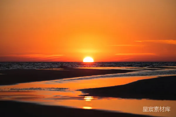 高清摄影 太阳正在海洋上空的海滩上落下。