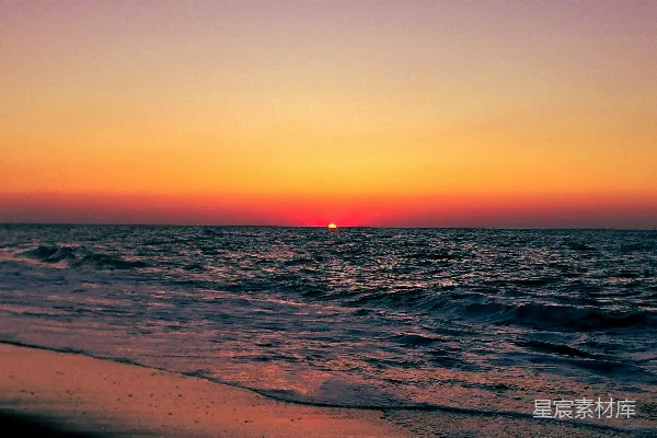 高清摄影 夕阳正在海滩上空的海面上落下。