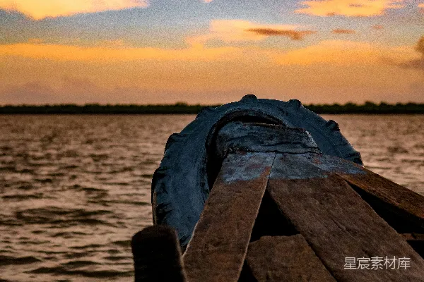 高清摄影 戴着黑色手套的人站在棕色木制码头上，夕阳西下。