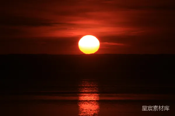 高清摄影 在多云的天气里，夕阳正缓缓沉入海洋。