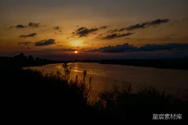 高清摄影 夕阳正沉落在一片水域之上。