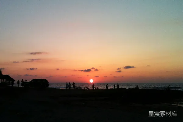 高清摄影 夕阳映照在海面上，人们在剪影中。