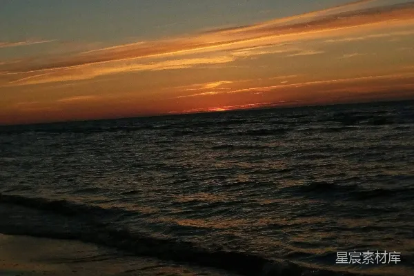 高清摄影 夕阳正挂在海面上的海滩上。