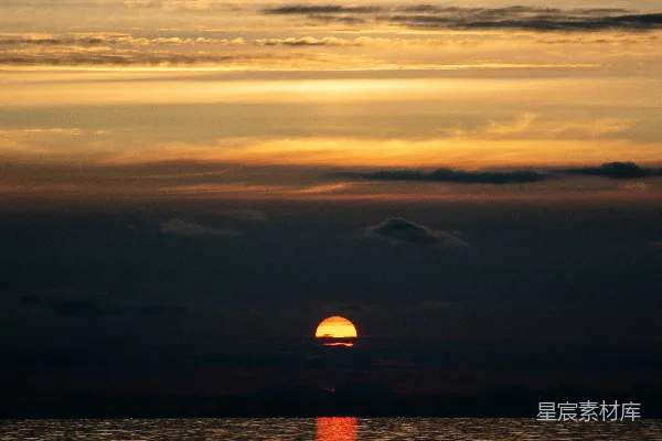 高清摄影 夕阳正缓缓落下，洒在海面上。