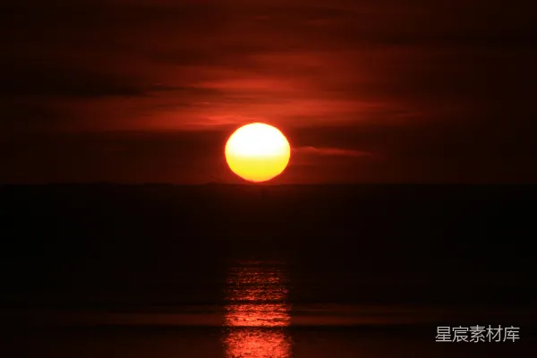 高清摄影 在多云的天气里，太阳正缓缓地落下，照耀着海洋。