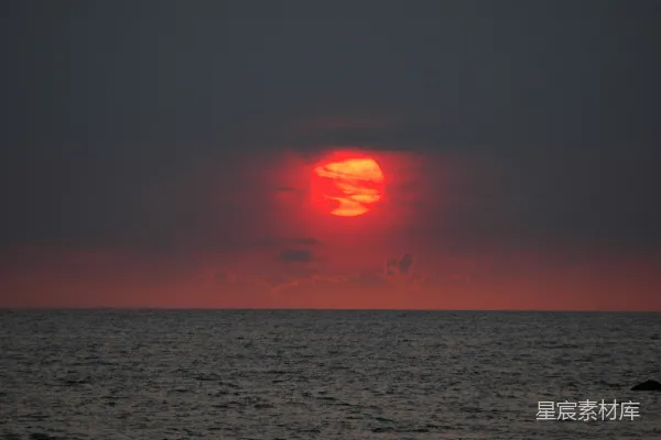 高清摄影 在一个多云的日子，太阳正缓缓地落下海面。