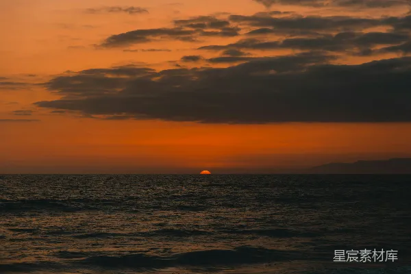 高清摄影 夕阳西下，海面上有一艘船在远处。